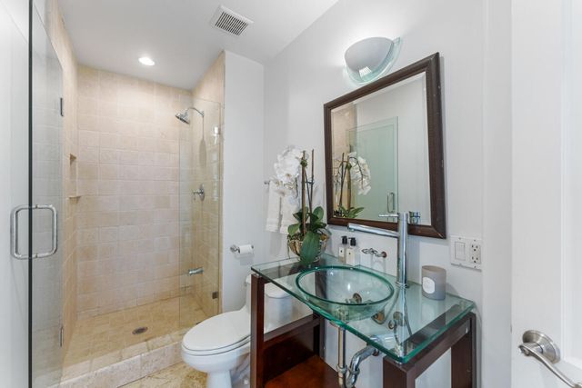 a bathroom with a granite countertop toilet a sink and a mirror