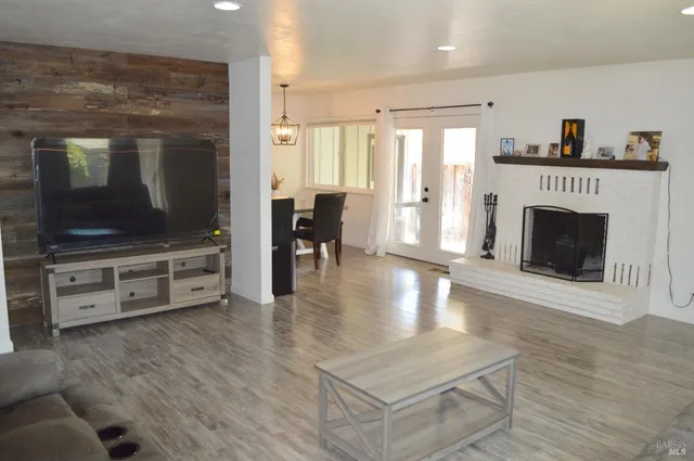 a living room with furniture a flat screen tv and a fireplace
