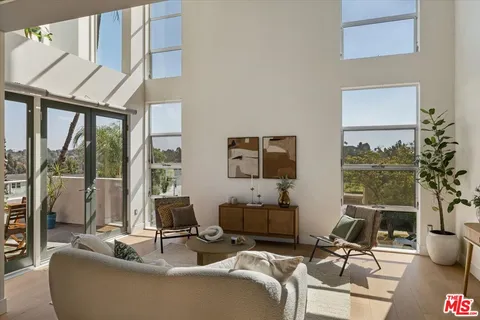 a living room with furniture a flat screen tv and a large window