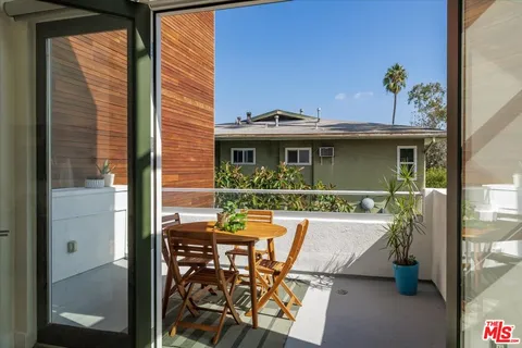a view of a patio with table and chairs and potted plants