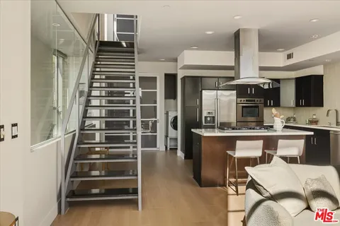 a kitchen with stainless steel appliances a stove refrigerator and cabinets