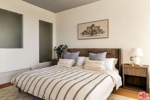 a bedroom with bed and painting on the wall