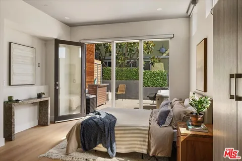 a living room with a balcony a bed furniture and a large window