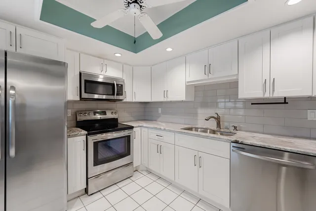 a kitchen with cabinets stainless steel appliances and a counter space