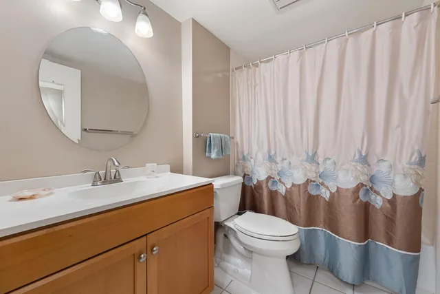 a bathroom with a toilet a sink a mirror a bathtub and vanity