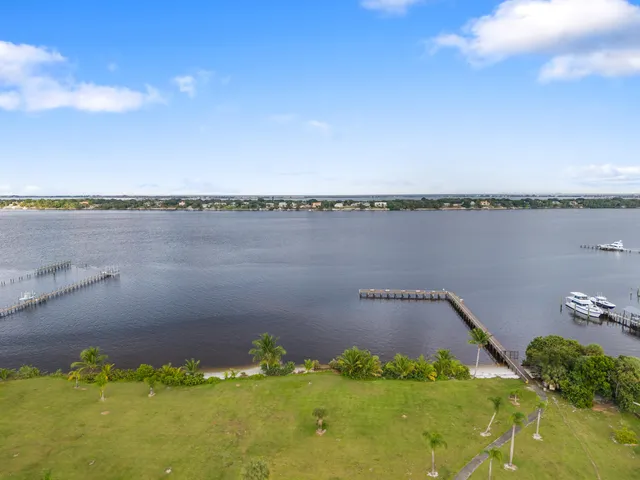 a view of a ocean with boats and trees in the background