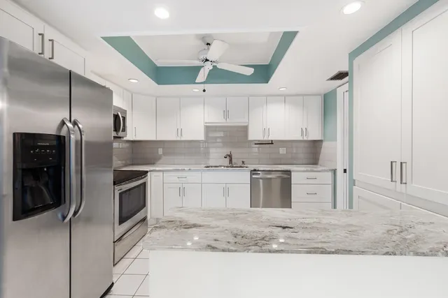 a kitchen with stainless steel appliances granite countertop a sink a stove and a refrigerator