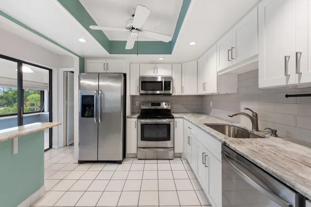 a kitchen with granite countertop a refrigerator and a sink