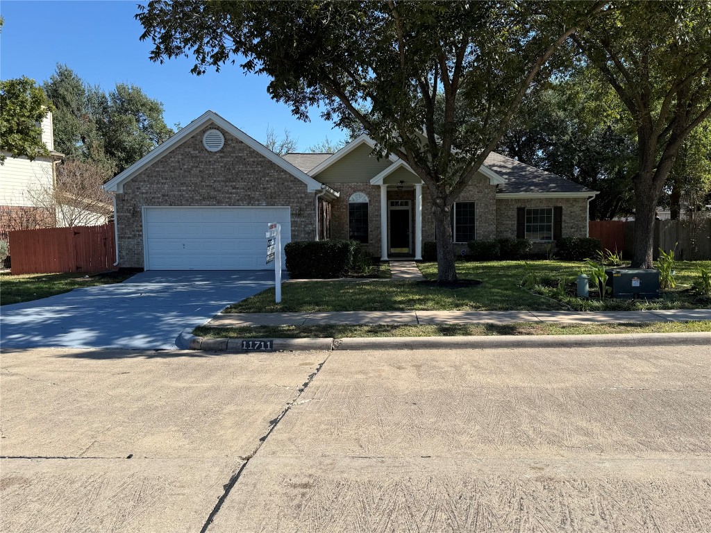 11711 Rydalwater Lane Austin, TX 78754 - Photo 1 of 20 Ranch-style home with concrete driveway, brick siding, and an attached garage