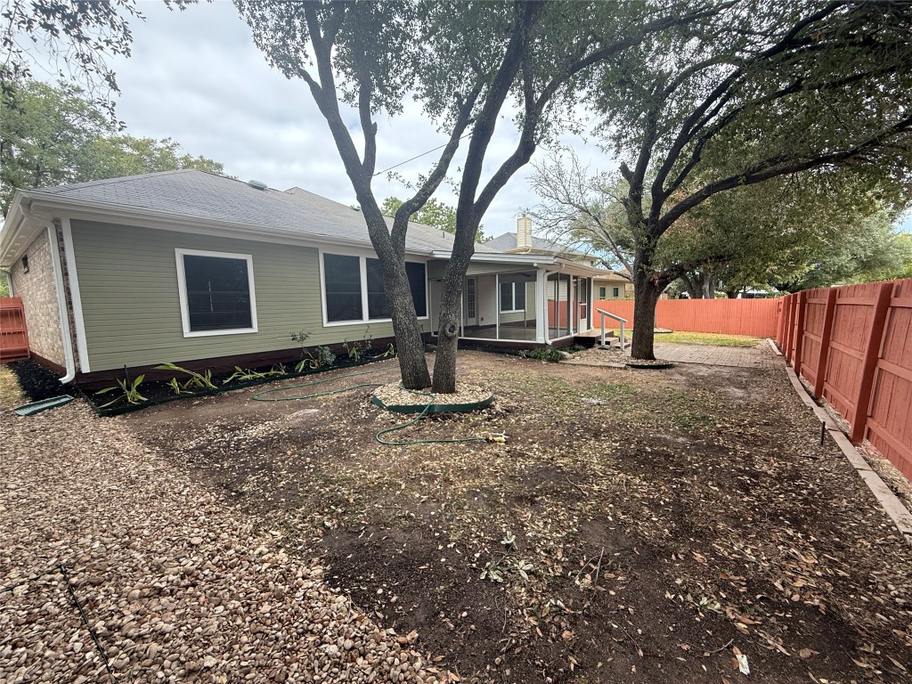 11711 Rydalwater Lane Austin, TX 78754 - Photo 19 of 20 Back of house with a fenced backyard, a sunroom, and a chimney