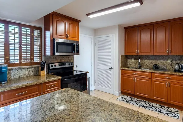 a kitchen with granite countertop a sink and a stove