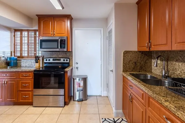 a kitchen with stainless steel appliances granite countertop a refrigerator and a stove