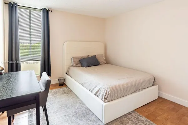 a bedroom with a bed and wooden floor