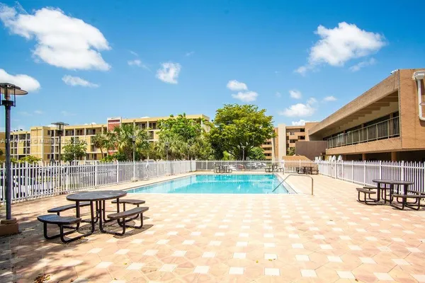a view of a swimming pool with outdoor seating and a yard