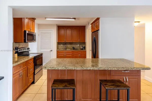 a kitchen with stainless steel appliances granite countertop a refrigerator and a stove top oven