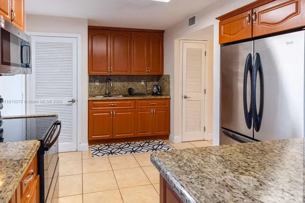 a kitchen with stainless steel appliances granite countertop a refrigerator stove and sink