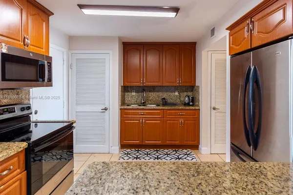 a kitchen with granite countertop wooden cabinets and a stove top oven