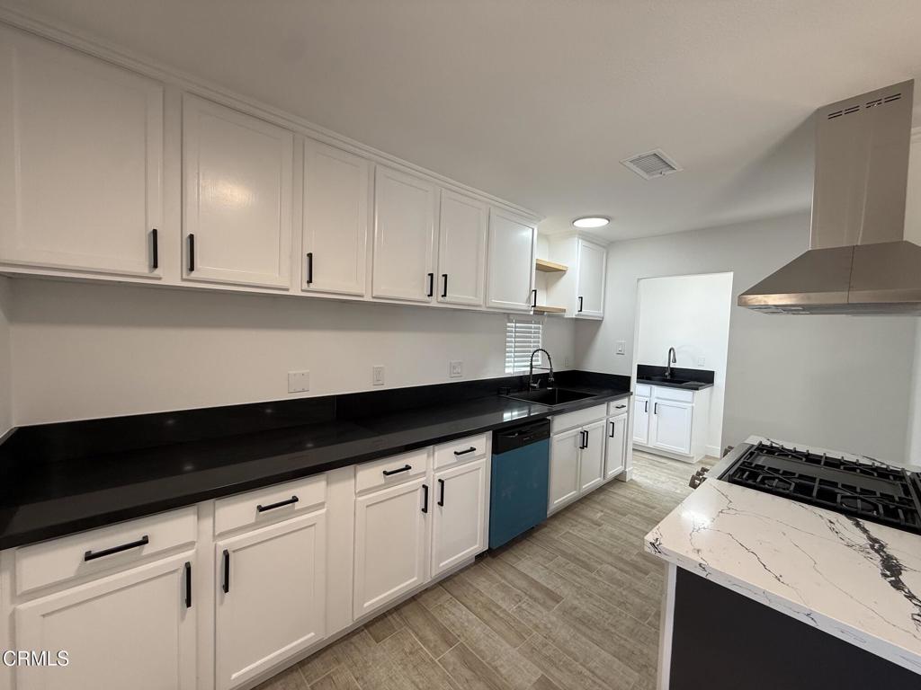 4010 Witt Avenue Riverside, CA 92501 - Photo 4 of 23 a kitchen with granite countertop white cabinets and black appliances