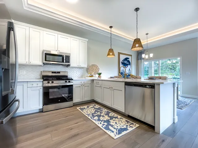 a kitchen with stainless steel appliances kitchen island granite countertop a stove a sink and a microwave