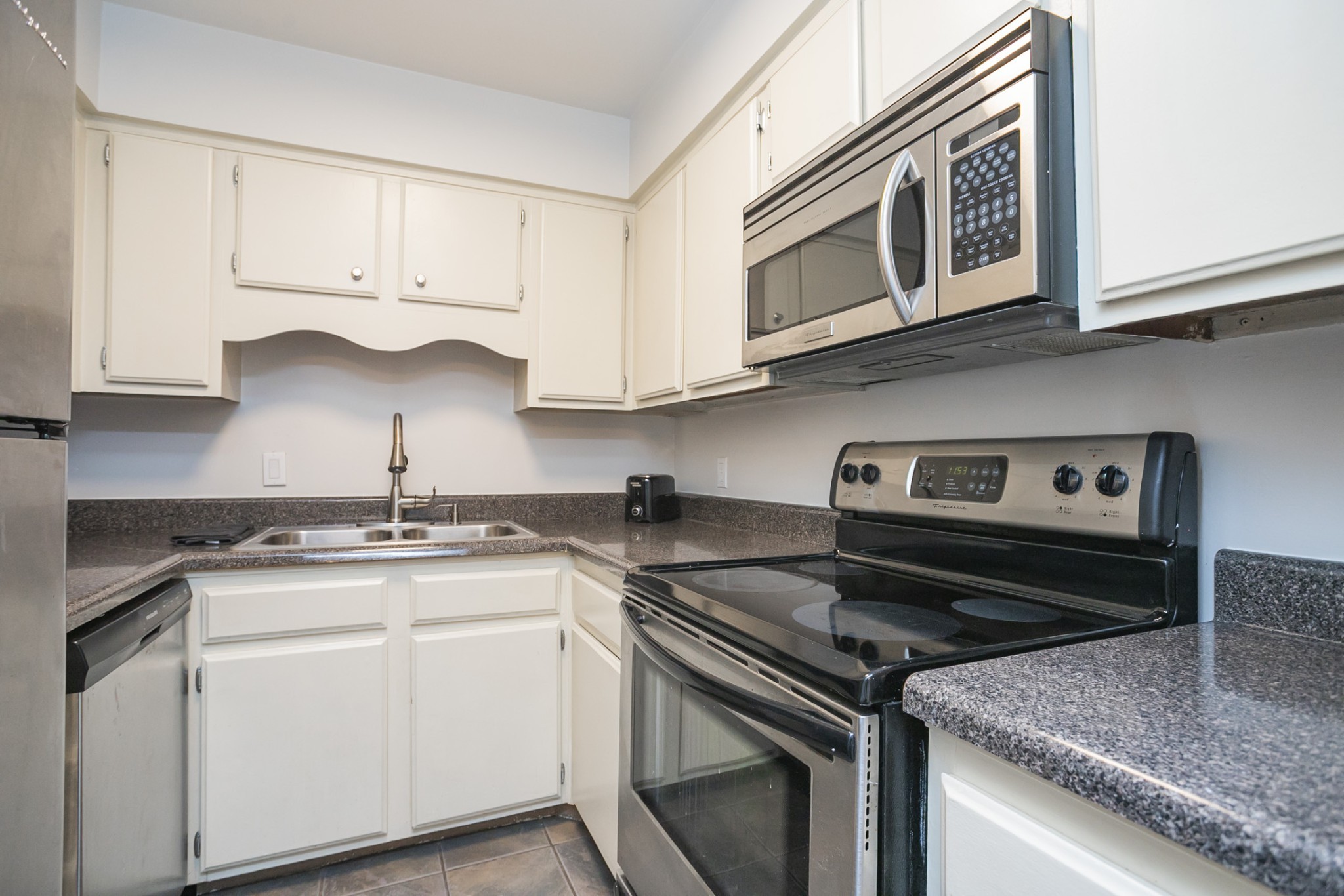 601 Boyd Mill Avenue, Unit C1 Franklin, TN 37064 - Photo 11 of 39 a kitchen with granite countertop white cabinets and a stove top oven
