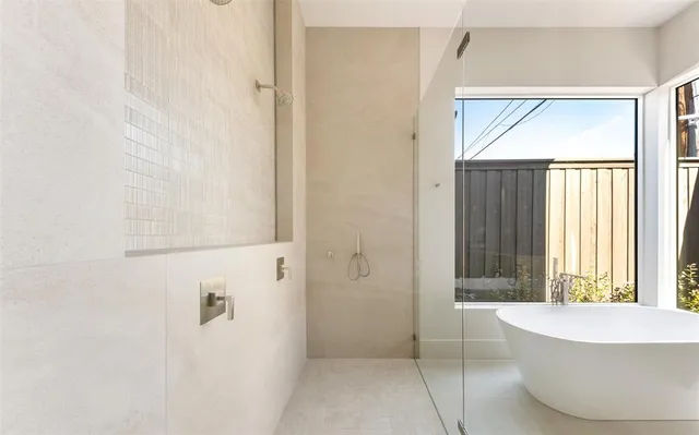 a bathroom with a white tub shower and window