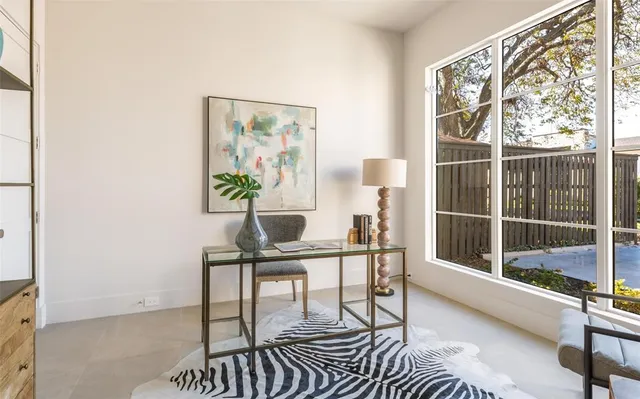 a view of a workspace with furniture and a window