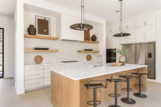 a kitchen with a table a refrigerator and cabinets
