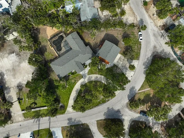 an aerial view of a house with a yard and tennis court