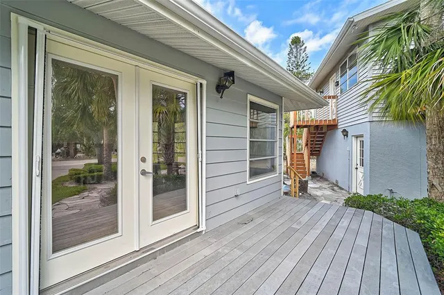 a view of a livingroom with a flesh screen tv and stairs