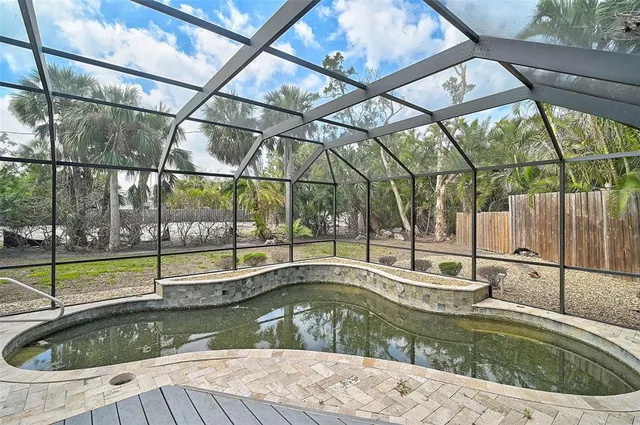 a kitchen with stainless steel appliances granite countertop a dining table chairs and a refrigerator