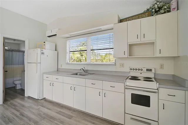 a living room with furniture large window and wooden floor