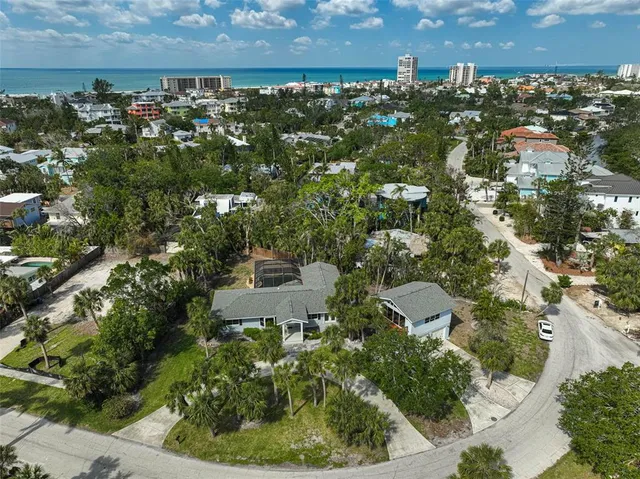 an aerial view of residential house with outdoor space and trees all around
