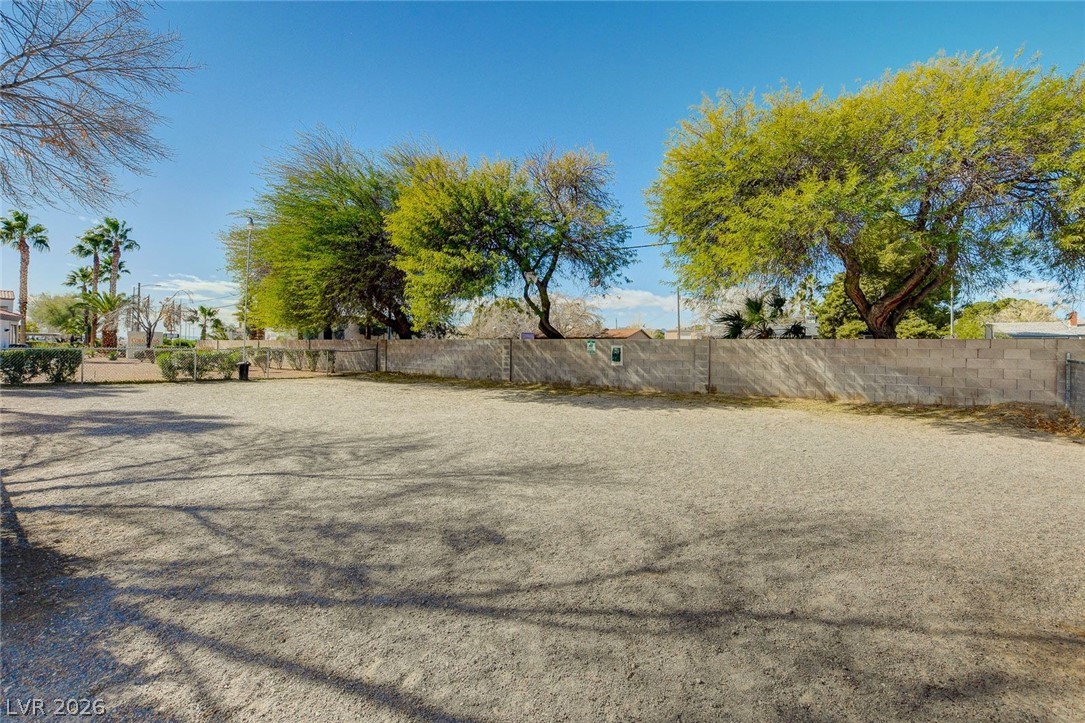 3318 North Decatur Boulevard, Unit 2072 Las Vegas, NV 89130 - Photo 45 of 50 A spacious, unpaved lot offers versatile outdoor potential, enclosed by a block wall and mature trees.