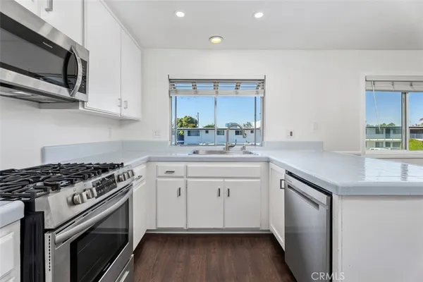 a kitchen with stainless steel appliances a sink stove and cabinets