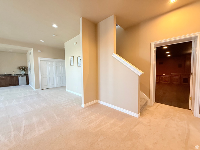 1562 Fairway Ridge Road Draper, UT 84020 - Photo 50 of 60 Expansive carpeted area featuring a wet bar with dark wood cabinetry and a stainless steel under-counter refrigerator