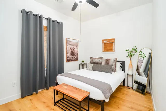 a bedroom with a bed table and a chandelier