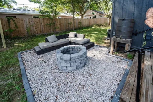 a view of a backyard with couches plants and large tree
