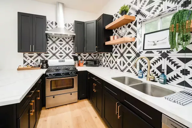 a kitchen with stainless steel appliances a sink stove and refrigerator