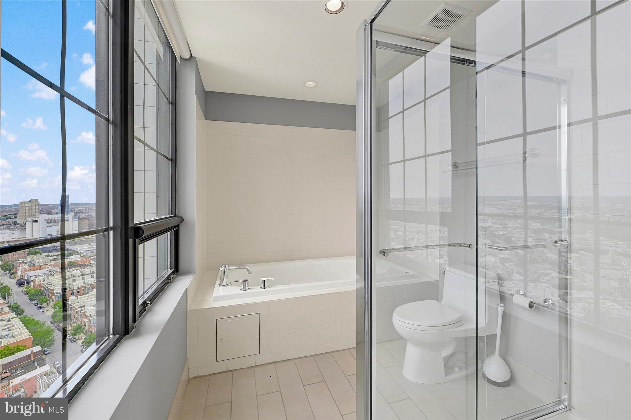 1200 Steuart Street, Unit 1913 Baltimore, MD 21230 - Photo 51 of 94 Glass shower & soaking tub with skyline views.