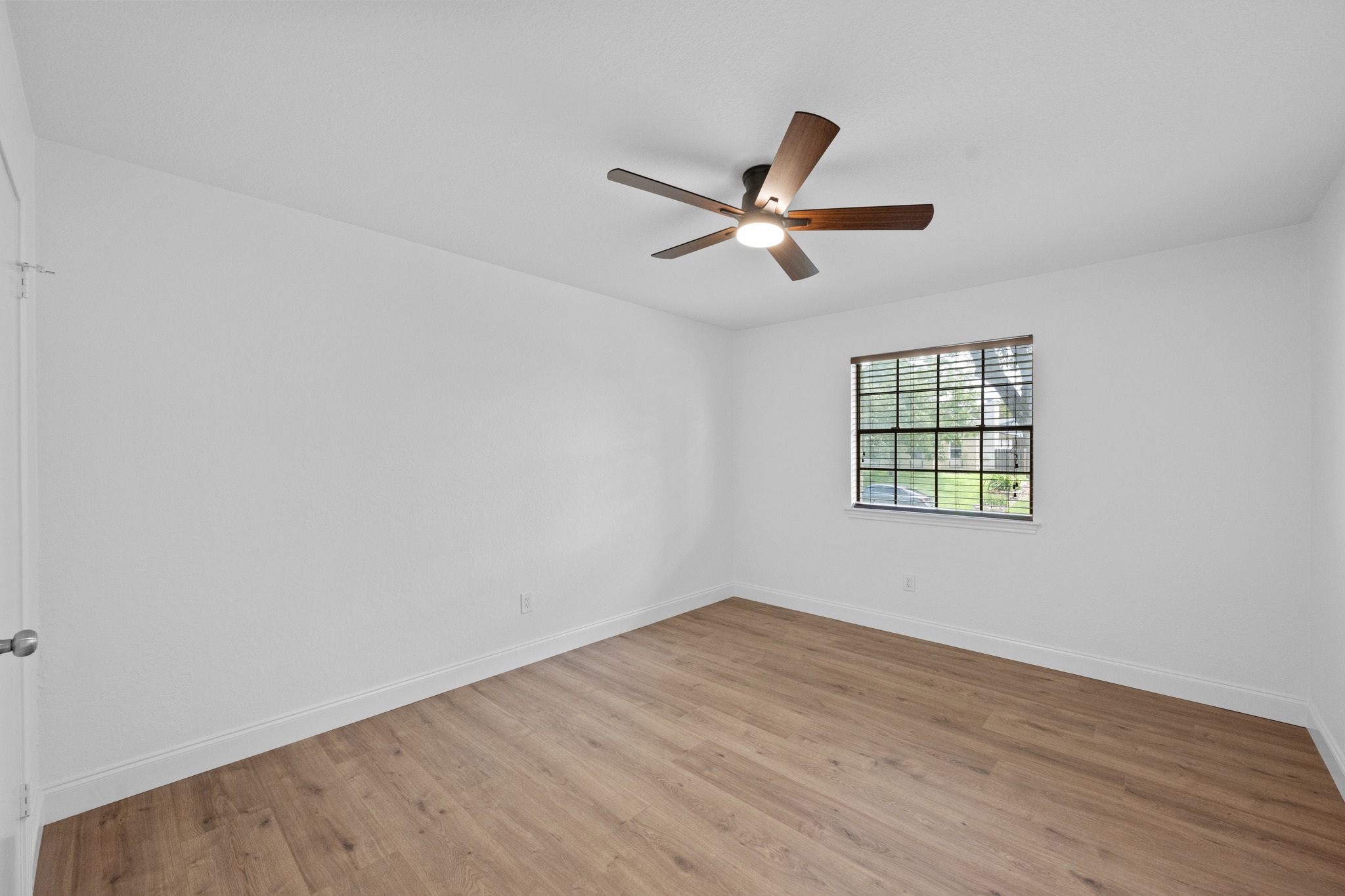 7210 Smokey Hill Road Austin, TX 78736 - Photo 23 of 29 A well-lit bedroom features durable laminate flooring and a functional ceiling fan with lighting.