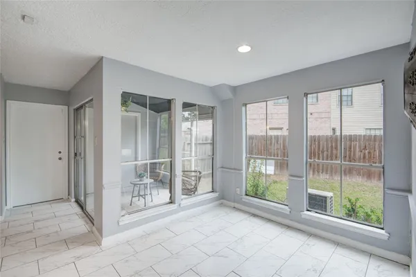 an empty room with a window and a fan