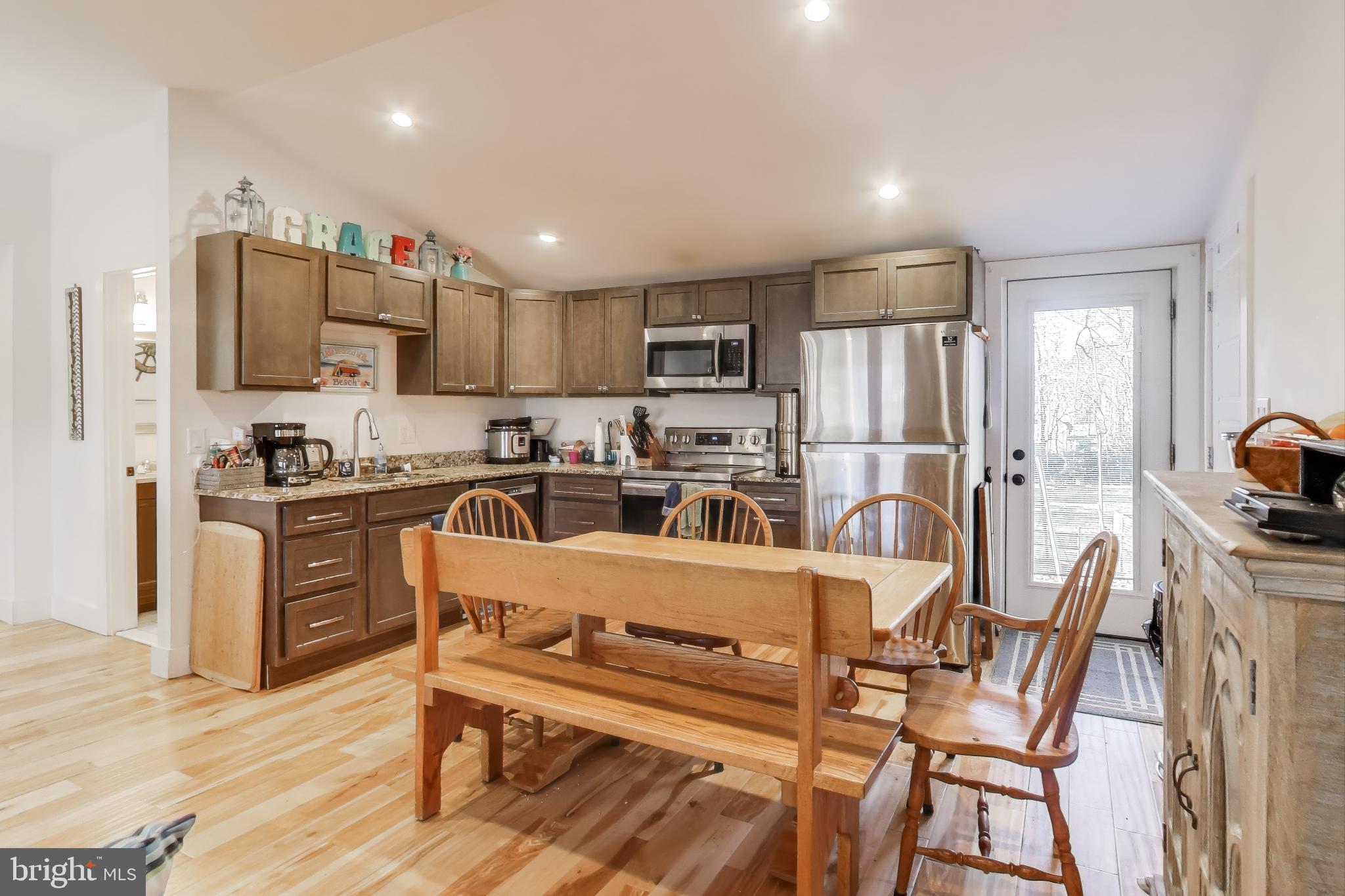 8238 WB&A Road Severn, MD 21144 - Photo 6 of 23 a kitchen with granite countertop a refrigerator stove microwave and cabinets