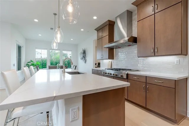 a kitchen with stainless steel appliances a table chairs in it and white cabinets
