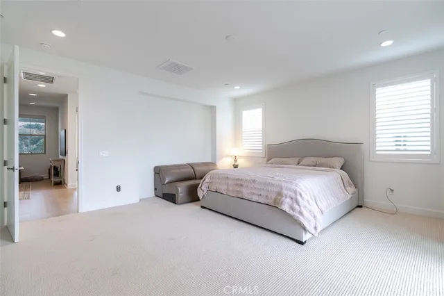 a bedroom with a large bed and a chandelier