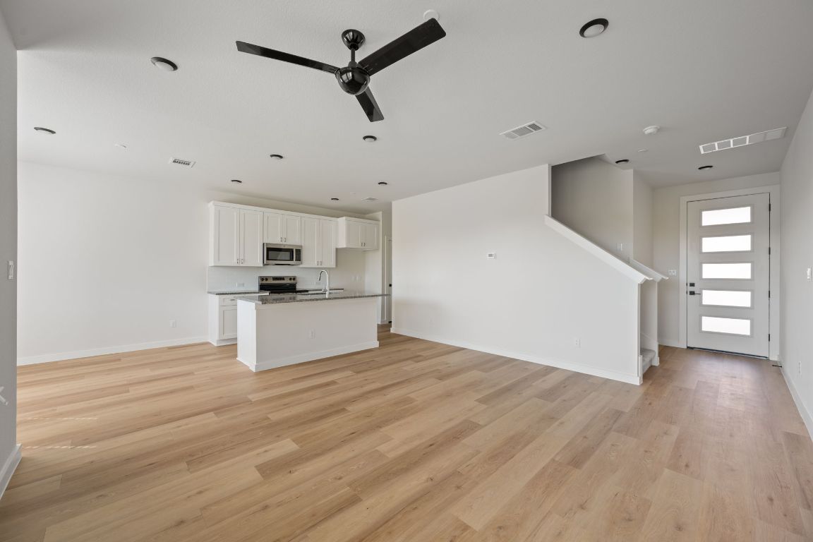 2600 Gattis School Road, Unit 1203 Round Rock, TX 78664 - Photo 3 of 25 Unfurnished living room with a ceiling fan and light wood-style flooring