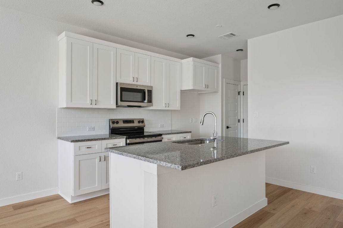 2600 Gattis School Road, Unit 1203 Round Rock, TX 78664 - Photo 7 of 25 Kitchen with dark stone counters, white cabinets, appliances with stainless steel finishes, and decorative backsplash