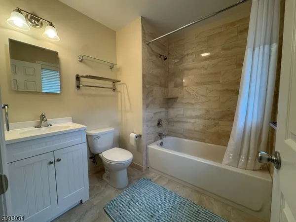 a bathroom with a bathtub shower sink vanity and toilet