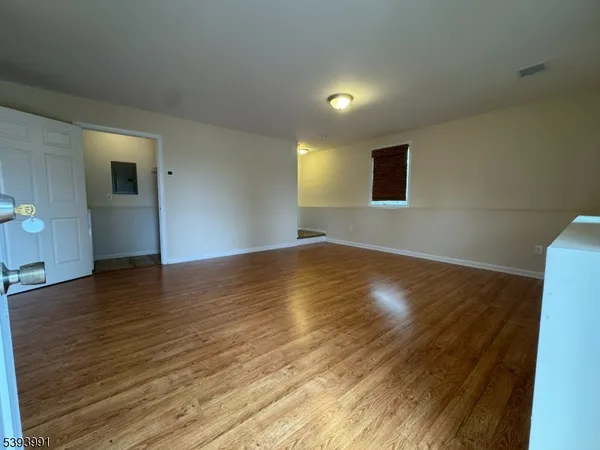 a view of room with wooden floor and windows