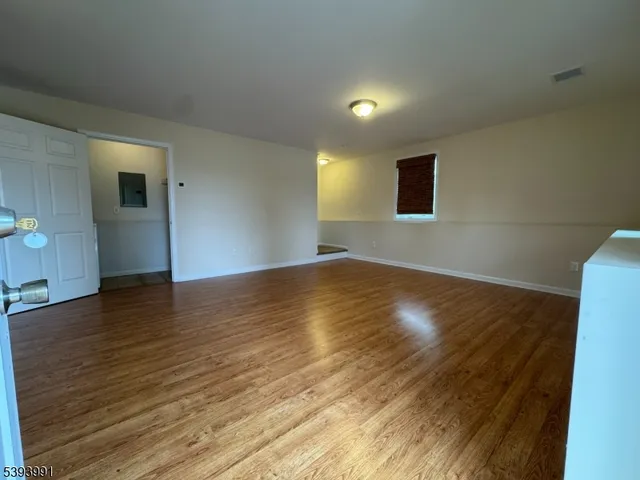 a view of room with wooden floor and windows