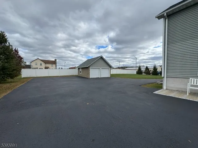 a view of a house with a big yard and large tree